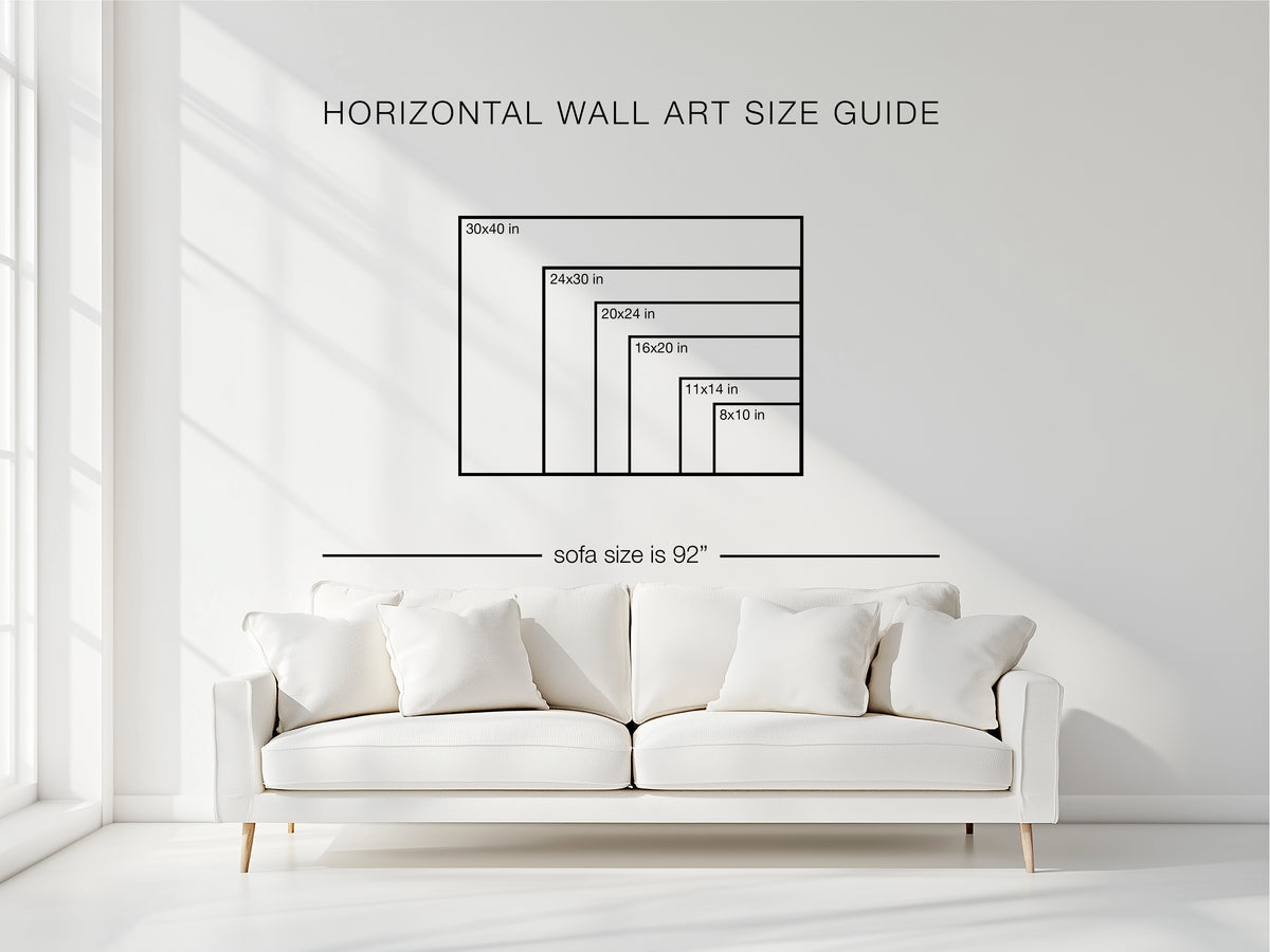 Horizontal wall art size guide showing framed artwork sizes above a white sofa in a bright modern living room