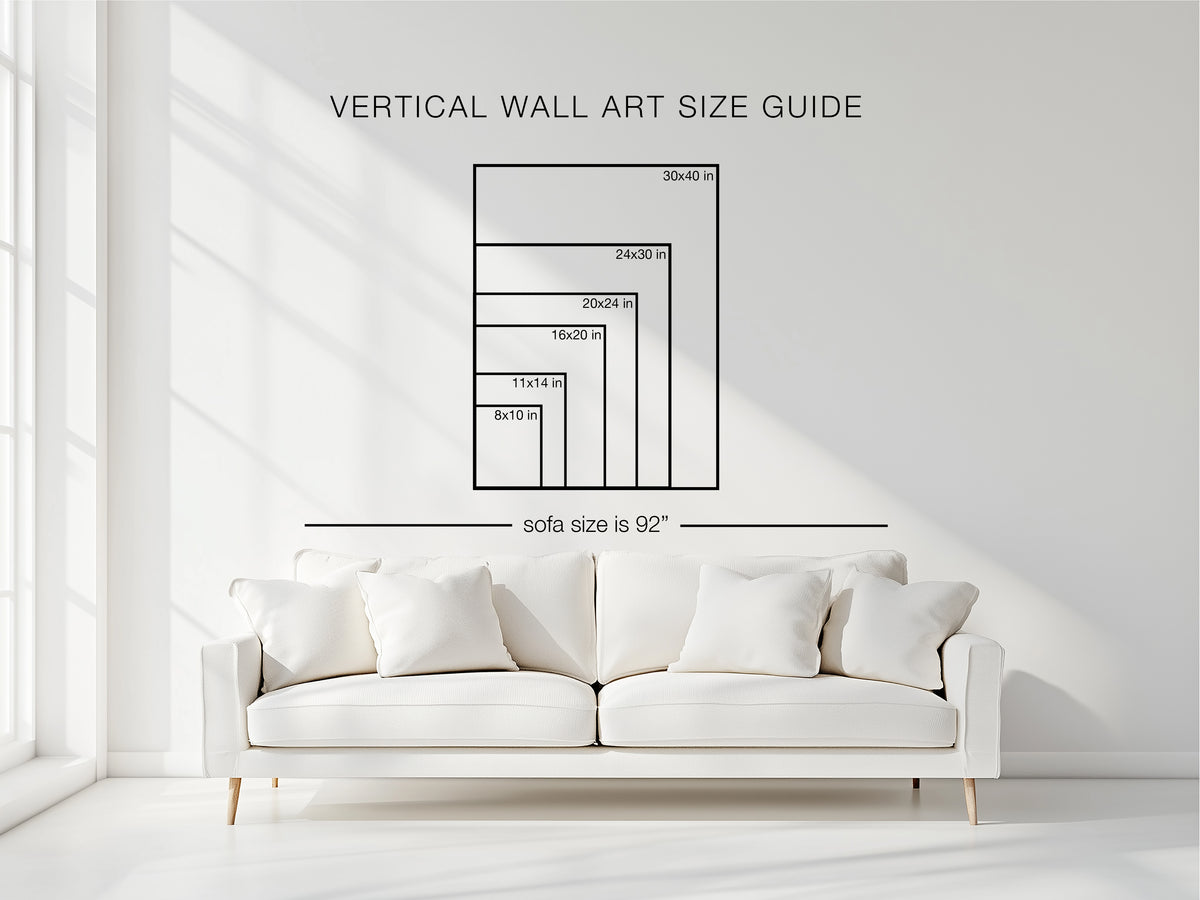 Vertical wall art size guide showing framed artwork sizes above a white sofa in a bright modern living room